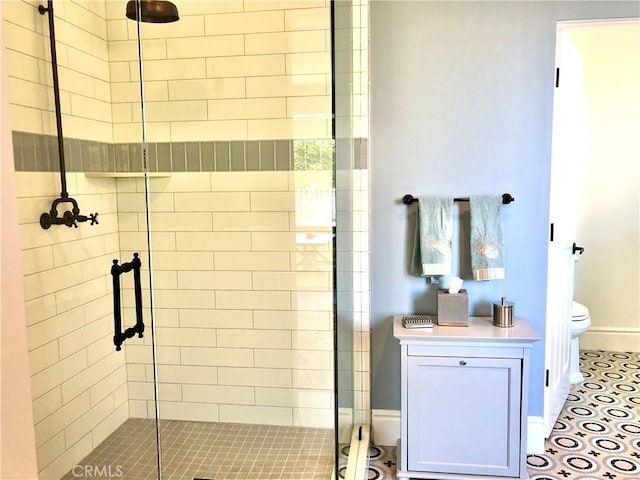 bathroom featuring a shower with door, toilet, and tile patterned flooring