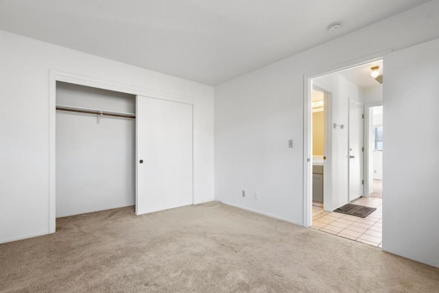 unfurnished bedroom with light colored carpet and a closet