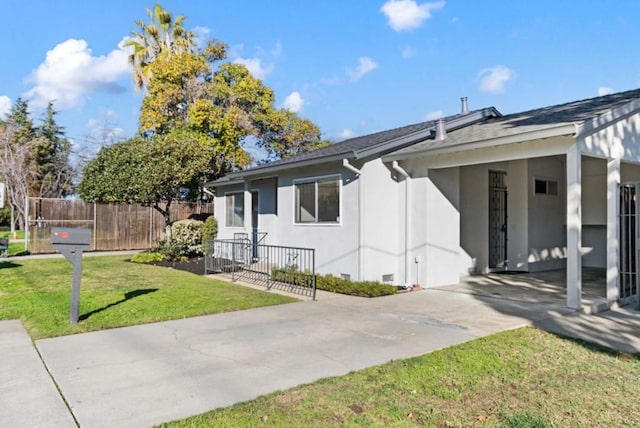 view of side of home featuring a yard and a carport