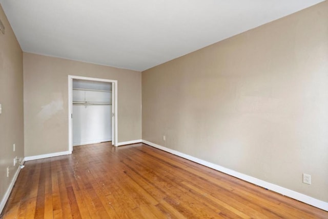 unfurnished bedroom featuring wood-type flooring and a closet