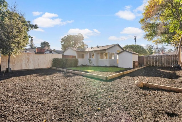 rear view of house with a storage shed