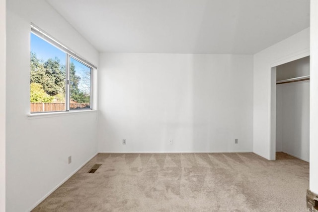 unfurnished bedroom featuring a closet and light carpet