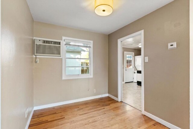 empty room with light wood-type flooring and a wall unit AC