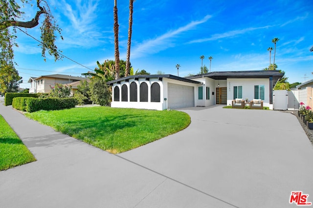 ranch-style house featuring a garage and a front lawn