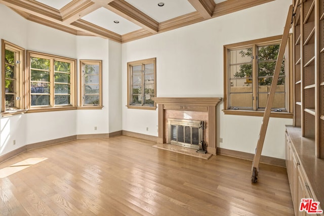 unfurnished living room with coffered ceiling, crown molding, light wood-type flooring, a high end fireplace, and beam ceiling