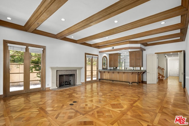 unfurnished living room with beamed ceiling, light parquet flooring, a high end fireplace, and french doors