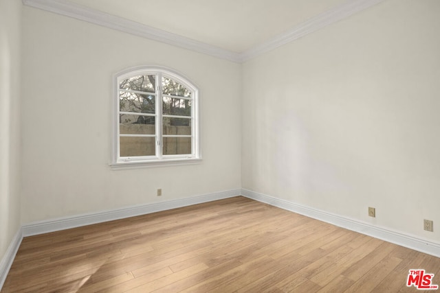 empty room featuring crown molding and light hardwood / wood-style flooring