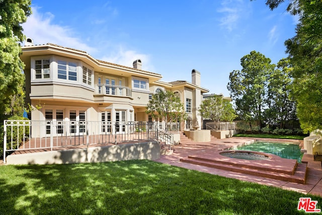 back of house with a lawn, a patio area, and french doors