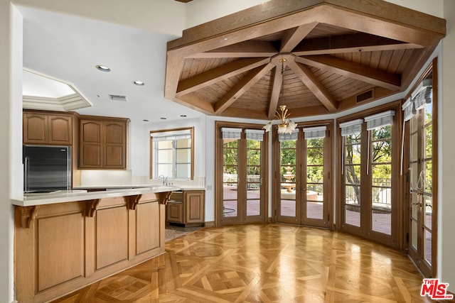 kitchen featuring wood ceiling, plenty of natural light, stainless steel built in fridge, kitchen peninsula, and light parquet floors