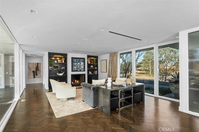 living room featuring built in shelves, a wall of windows, and dark parquet flooring