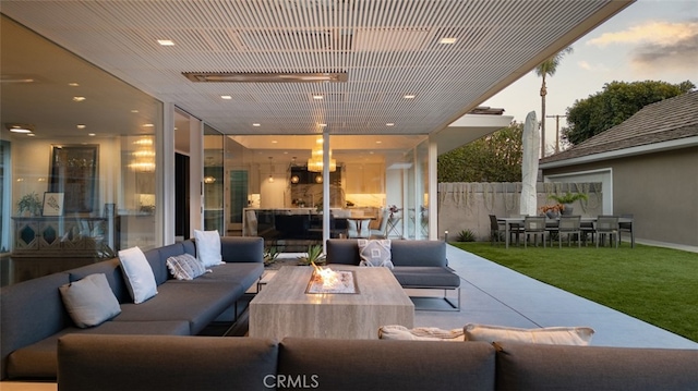 patio terrace at dusk featuring an outdoor living space with a fire pit