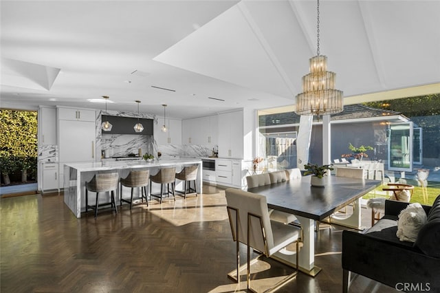 dining space featuring a chandelier and dark parquet floors