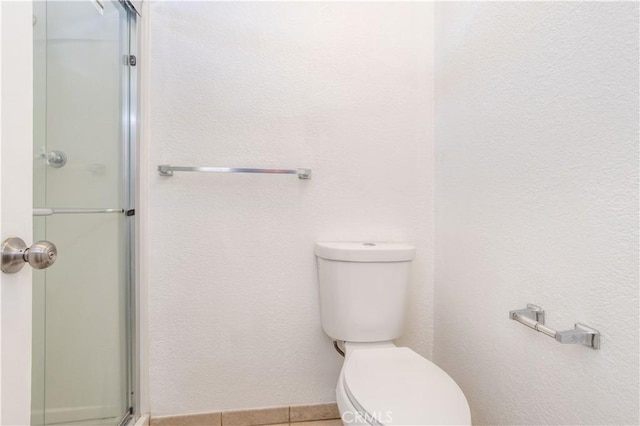 bathroom featuring toilet and walk in shower