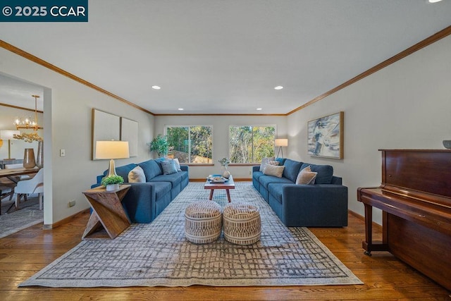 living room with crown molding, dark wood-type flooring, and an inviting chandelier