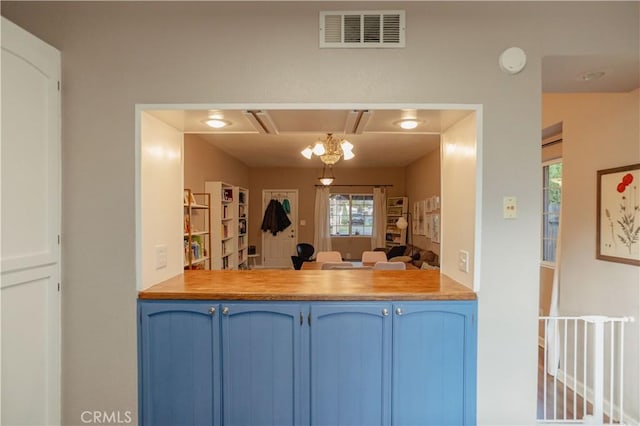 kitchen featuring light countertops, a peninsula, visible vents, and blue cabinets