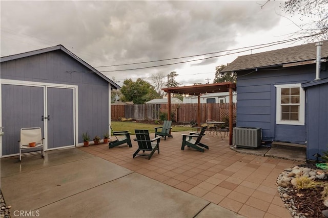 view of patio / terrace with fence, cooling unit, and an outbuilding