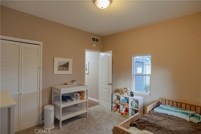 carpeted bedroom with baseboards, visible vents, and a closet