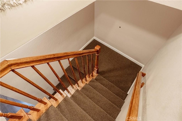 stairs featuring carpet floors and baseboards