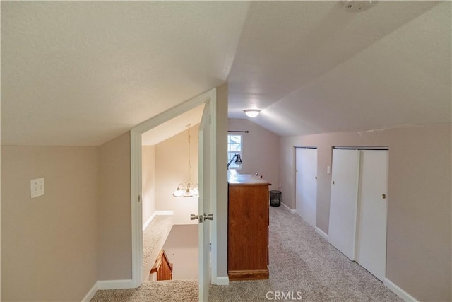 additional living space featuring carpet flooring, baseboards, and lofted ceiling