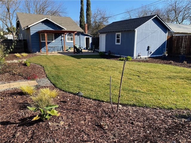 view of yard featuring fence, a patio, and an outdoor structure