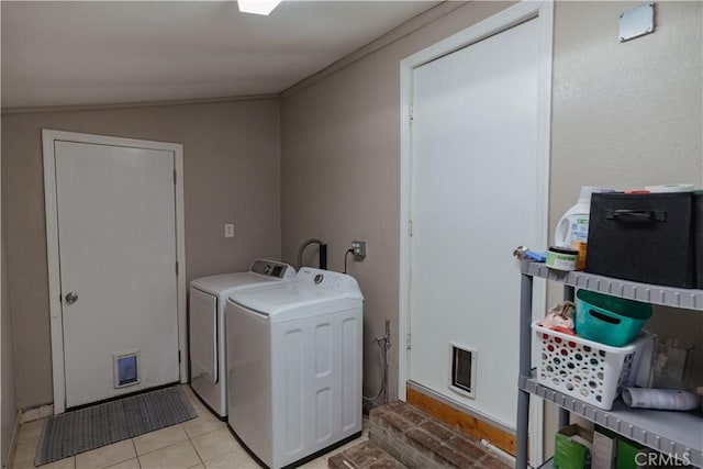 washroom with light tile patterned floors, ornamental molding, laundry area, and washing machine and dryer
