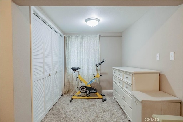 exercise area featuring baseboards and carpet