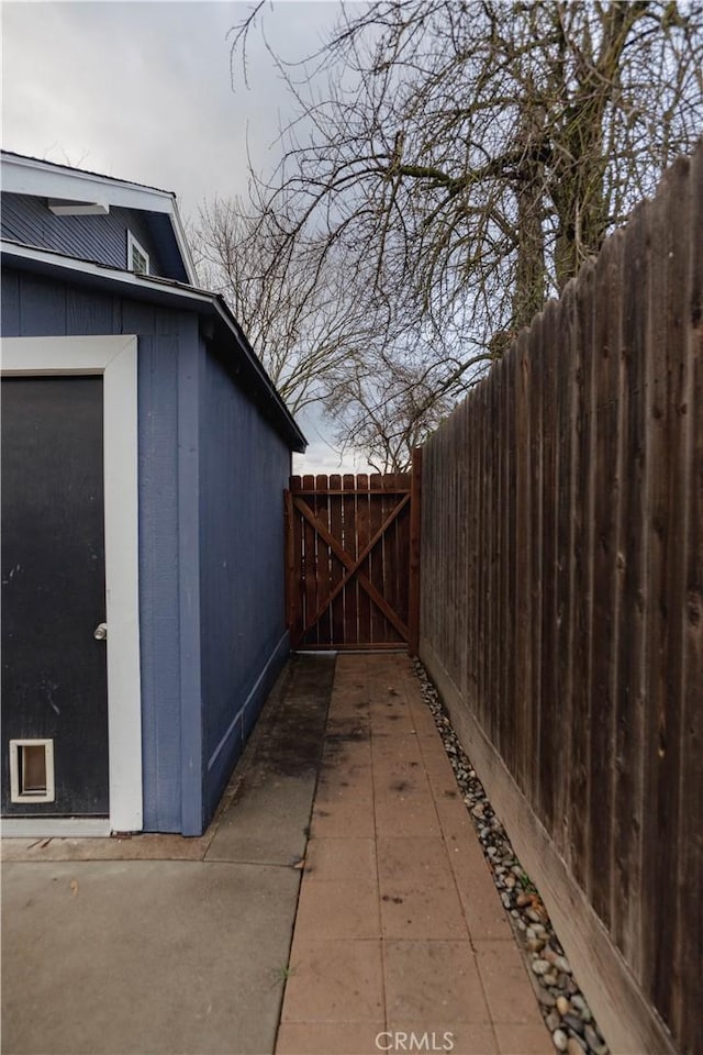 view of side of home featuring fence and a gate