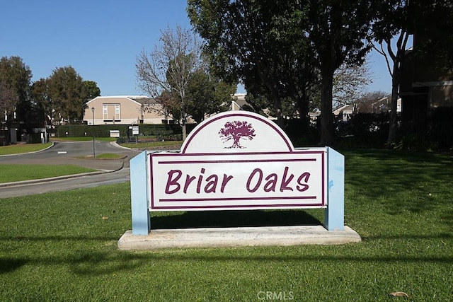 community / neighborhood sign with a yard