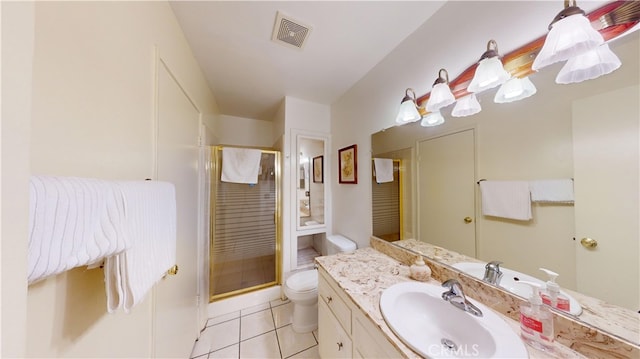 bathroom featuring tile patterned floors, vanity, toilet, and a shower with door