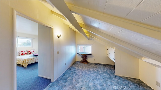 additional living space with dark colored carpet and vaulted ceiling