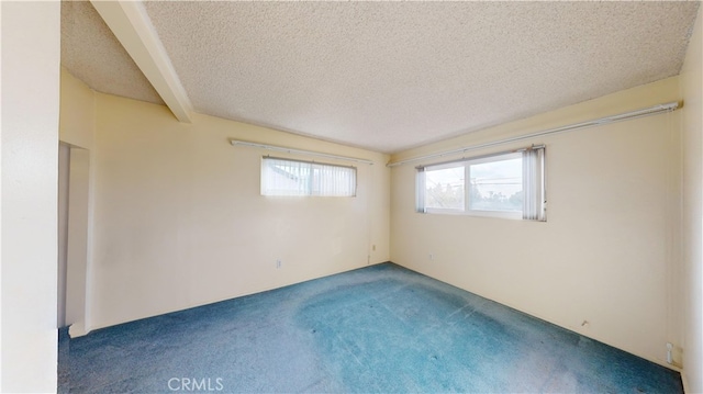 carpeted empty room featuring beamed ceiling and a textured ceiling