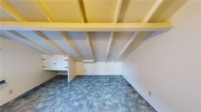 additional living space featuring beam ceiling and dark carpet