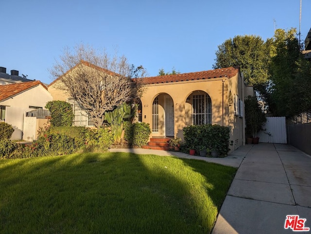 mediterranean / spanish-style house featuring a front lawn