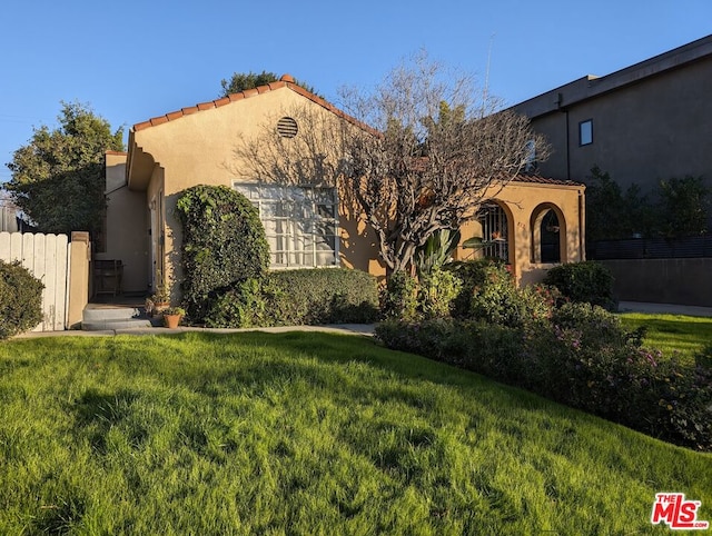 mediterranean / spanish-style house with a front yard