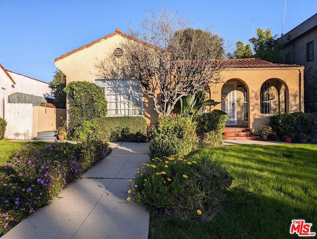 mediterranean / spanish home with a front lawn