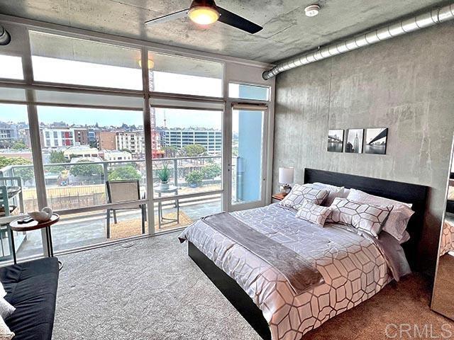 bedroom with ceiling fan, carpet, and multiple windows