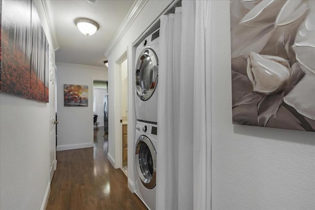 laundry room featuring dark hardwood / wood-style flooring, crown molding, and stacked washer and dryer