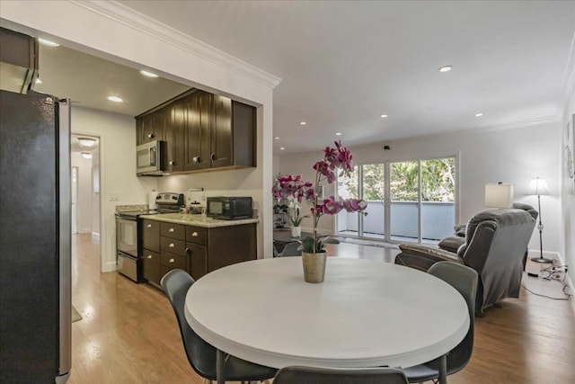 dining area featuring crown molding and light wood-type flooring