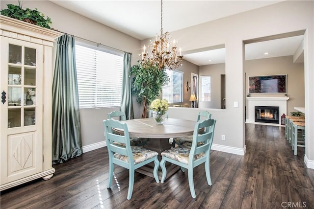 dining space with dark wood-type flooring, a notable chandelier, and a healthy amount of sunlight