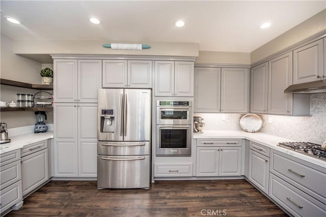 kitchen featuring dark hardwood / wood-style flooring, tasteful backsplash, gray cabinetry, and appliances with stainless steel finishes