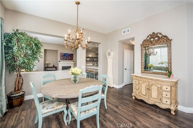 dining space featuring dark wood-type flooring and a notable chandelier