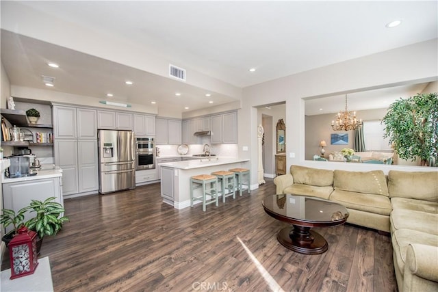 living room with sink, dark hardwood / wood-style floors, and a chandelier