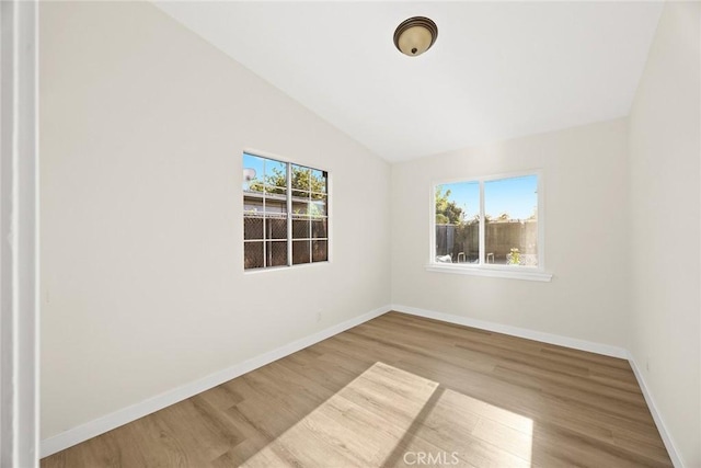 unfurnished room featuring light hardwood / wood-style flooring and vaulted ceiling