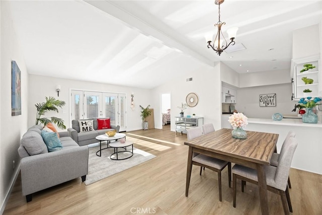 dining area featuring light hardwood / wood-style floors, lofted ceiling with beams, french doors, and an inviting chandelier