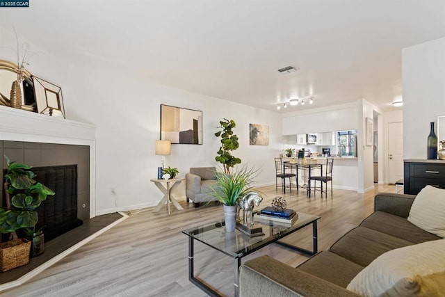 living room featuring a tile fireplace and hardwood / wood-style floors