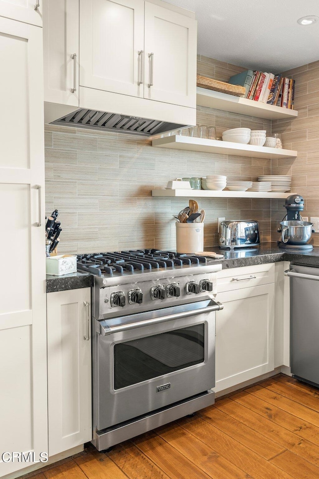 kitchen with white cabinetry, premium range, light wood-type flooring, and tasteful backsplash