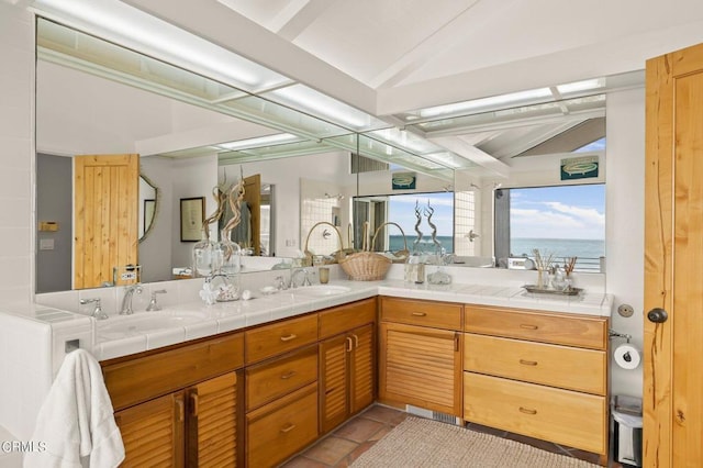 bathroom with vanity, a water view, tile patterned floors, and lofted ceiling