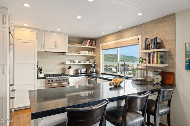 kitchen with a breakfast bar, white cabinetry, and stainless steel appliances