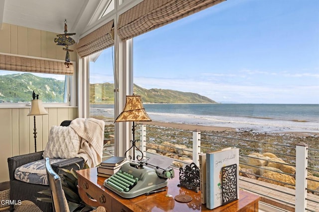 interior space featuring a beach view, lofted ceiling, and a water view