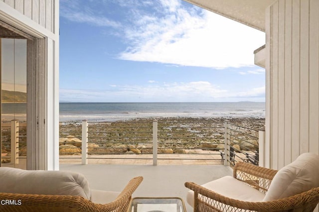 balcony featuring a beach view and a water view